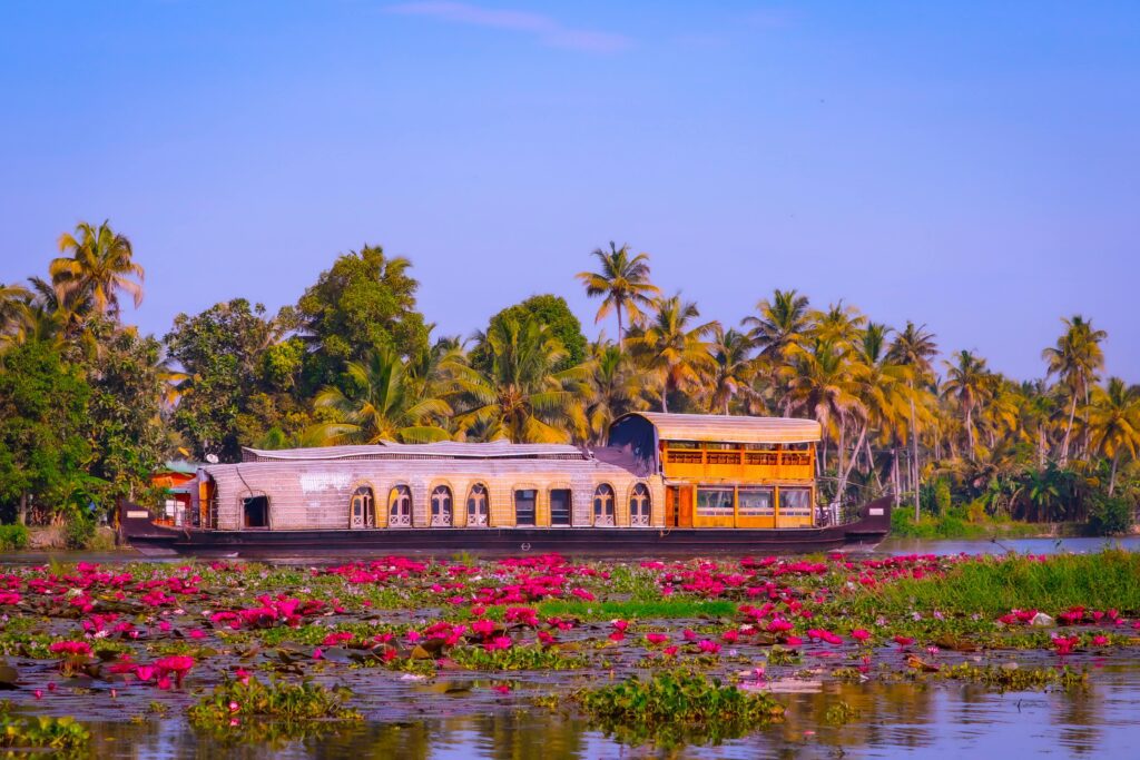A happy family posing on a traditional houseboat in the Alleppey backwaters on a Kerala family tour package.