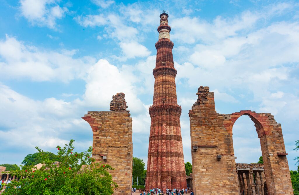 Tourists exploring Qutub Minar complex with guide in Delhi UNESCO World Heritage site