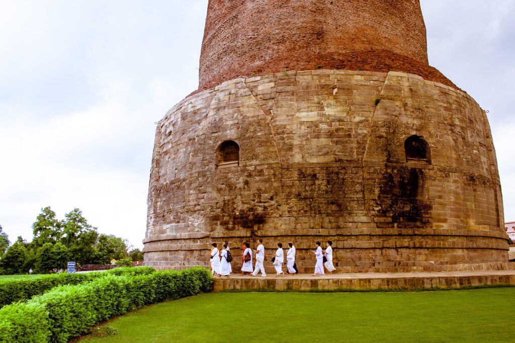Engaged travelers listening to a Shamrock Journeys expert guide explaining history at Sarnath near Varanasi.