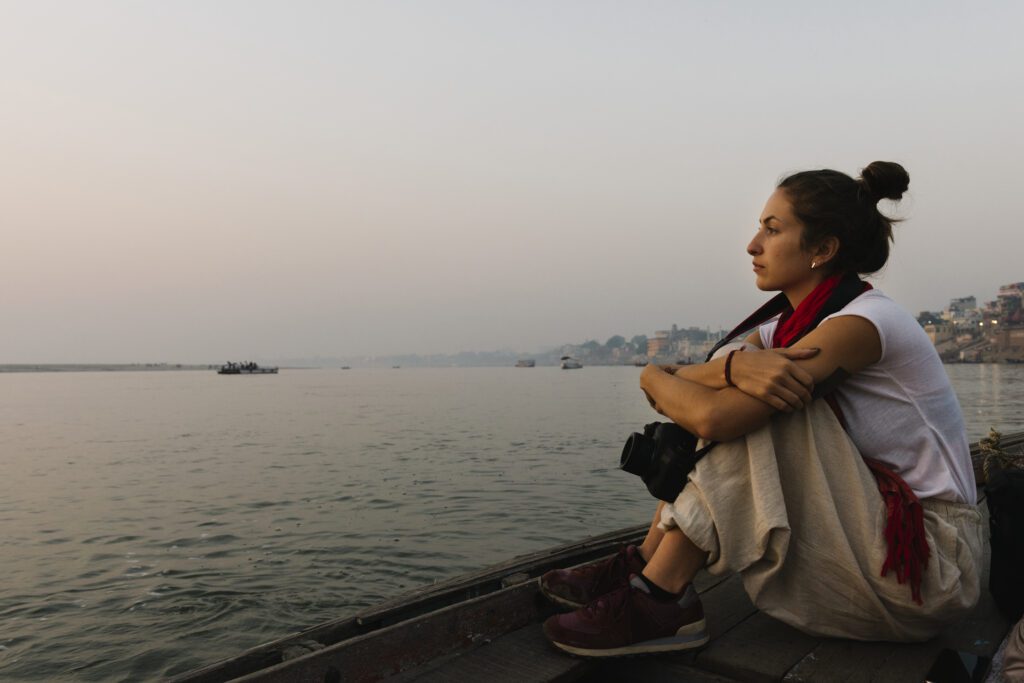 Traveler enjoying a quiet moment of reflection on the stone steps of a Varanasi ghat during a 3-day tour.