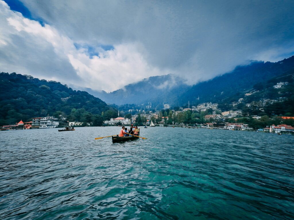 Boating on Naini Lake with mountain views in Nainital - popular hill station in North India tour packages.