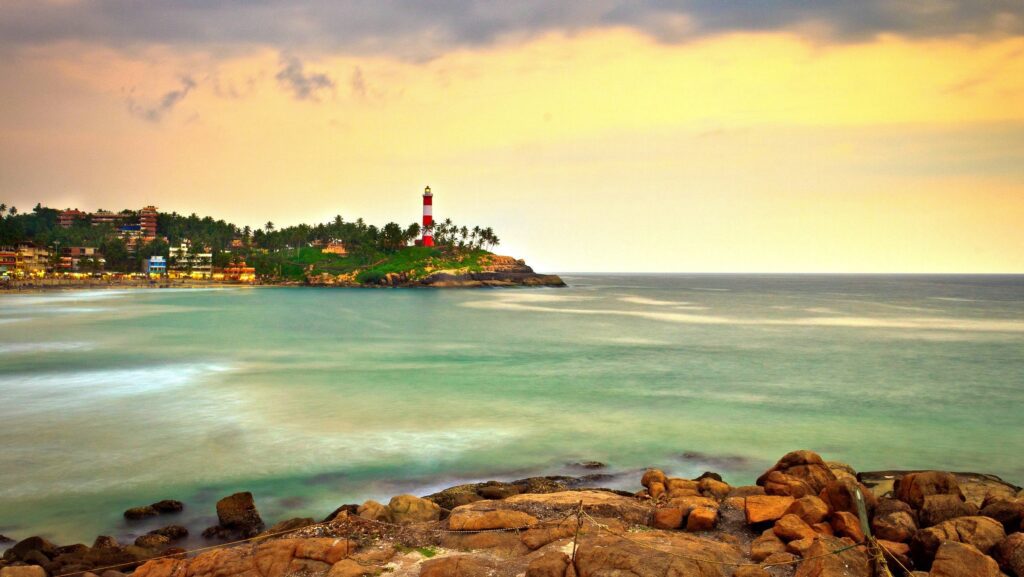 A honeymoon couple enjoying a private candlelit dinner on the beach at sunset in Kovalam, Kerala.