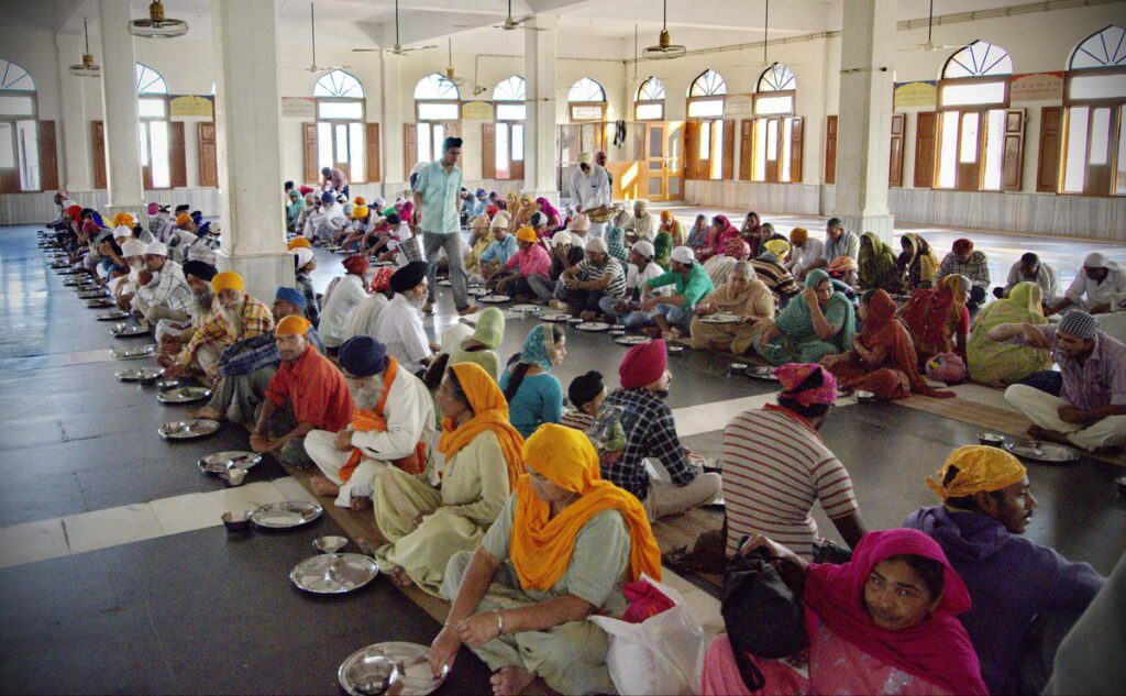 Volunteers serving vegetarian langar at Golden Temple Amritsar - world's largest free community kitchen