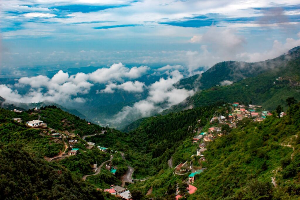 Panoramic view of Mussoorie hill station, Uttarakhand, with misty Himalayan mountains and colonial-era buildings