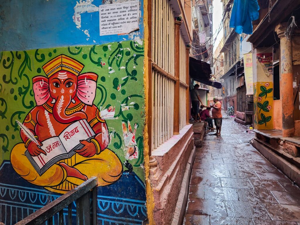 A local Shamrock Journeys guide explaining the history of Varanasi's ancient, narrow alleyways to travelers.