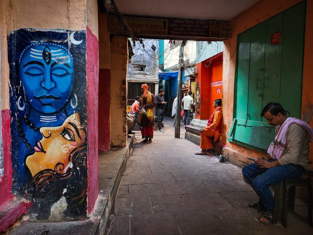 A local Shamrock Journeys guide explaining the history of Varanasi's ancient, narrow alleyways to travelers.