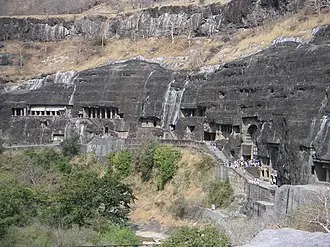 Exterior view of the horse-shoe shaped Ajanta Caves carved into a cliff face