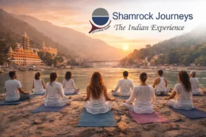 Group practicing yoga and meditation at sunrise in Rishikesh, the world capital of yoga, by the Ganges River.