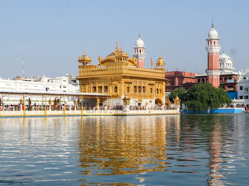 Golden Temple (Harmandir Sahib) Amritsar tour, devotees at the sarovar pool with stunning golden architecture reflected in water