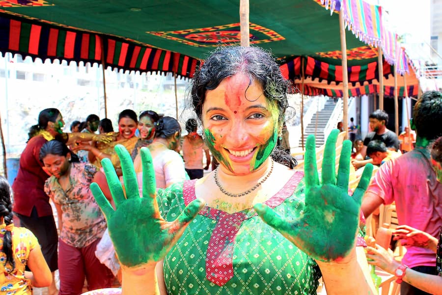 Travelers and locals celebrating Holi festival colors on a cultural tour of India with Shamrock Journeys