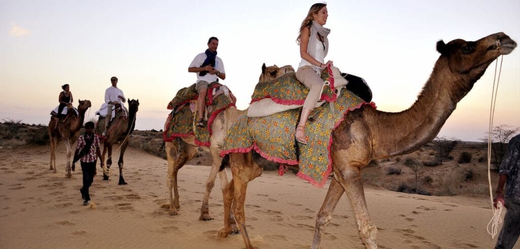 Jaisalmer Fort rising from the Thar Desert with camel safari across the Sam Sand Dunes