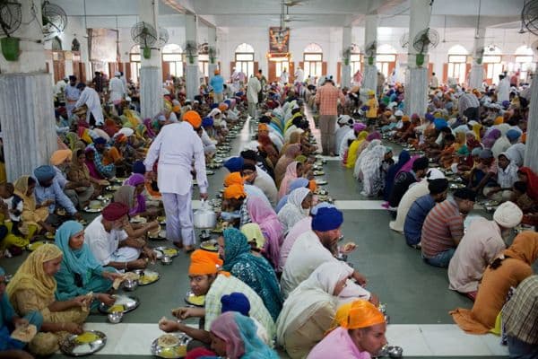 Volunteers serving vegetarian langar at Golden Temple Amritsar, world's largest free community kitchen