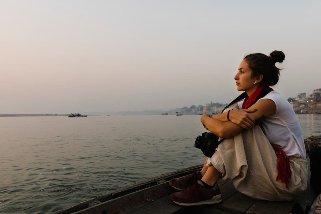 Varanasi tour packages: Traveler sitting on the stone steps of a ghat by the Ganga in Varanasi